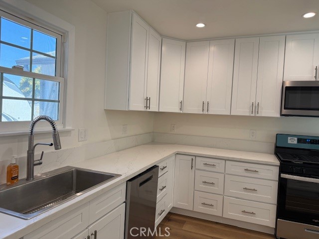 7964 Comolette Street Downey, CA 90242 - Photo 6 of 22 a kitchen with white cabinets and sink