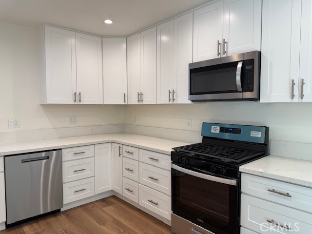 7964 Comolette Street Downey, CA 90242 - Photo 7 of 22 a kitchen with white cabinets and stainless steel appliances