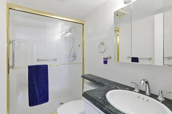 a bathroom with a sink and mirror with toilet