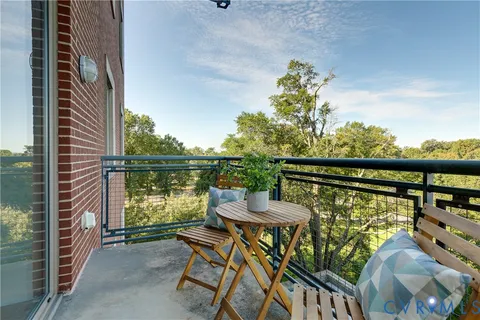 a balcony with table and chairs and wooden floor