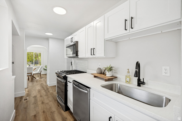 662 29th Street Ogden, UT 84403 - Photo 6 of 23 Contemporary kitchen featuring white shaker cabinetry with matte black hardware, stainless steel appliances, a single basin undermount sink with a black gooseneck faucet, and light-toned countertops