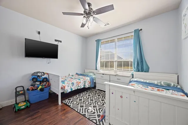 a bedroom with furniture a flat screen tv and a window