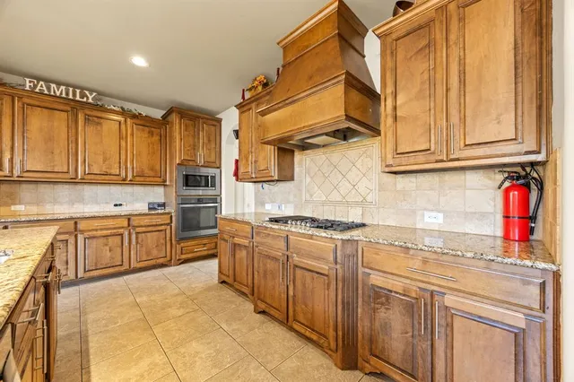 a kitchen with stainless steel appliances granite countertop a stove a sink and a refrigerator