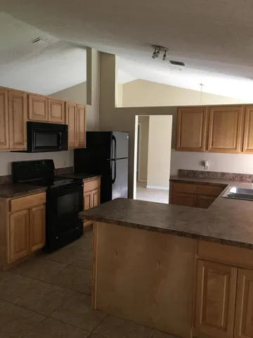 a kitchen with stainless steel appliances granite countertop a stove a sink and a microwave