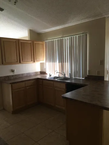 a kitchen with granite countertop a sink and a white cabinets