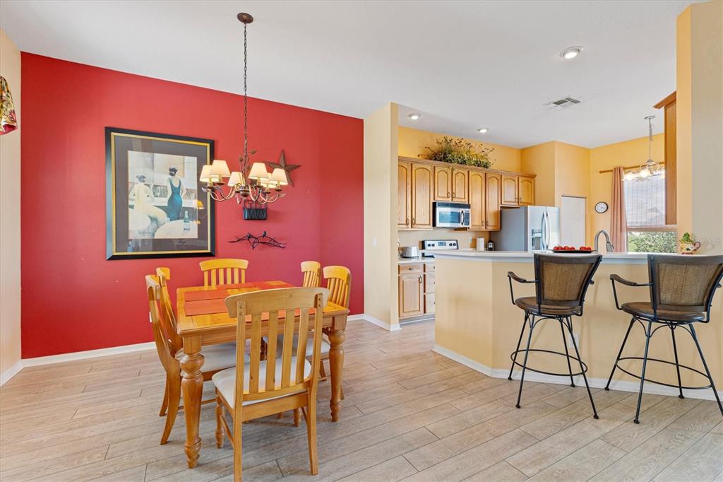 17739 Southeast 121st Terrace Road Summerfield, FL 34491 - Photo 4 of 48 a dining room with furniture a chandelier and wooden floor