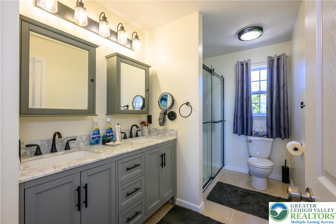 1252 Center Street Coplay, PA 18037 - Photo 34 of 63 a spacious bathroom with a granite countertop sink a toilet a mirror and a shower