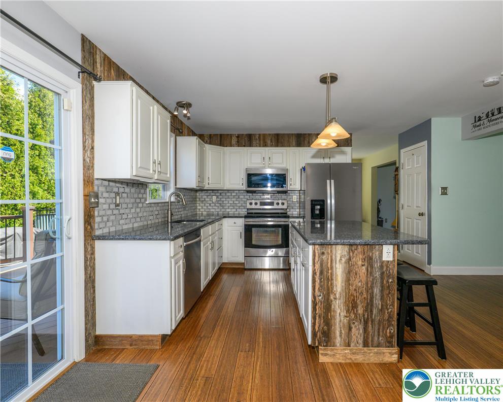 1252 Center Street Coplay, PA 18037 - Photo 6 of 63 a kitchen with stainless steel appliances granite countertop a stove top oven a sink dishwasher a refrigerator and white cabinets with wooden floor