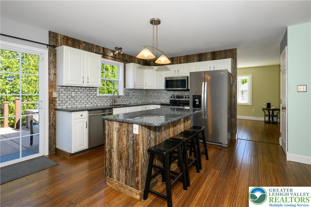 1252 Center Street Coplay, PA 18037 - Photo 7 of 63 a kitchen with stainless steel appliances granite countertop wooden floors a stove and a microwave