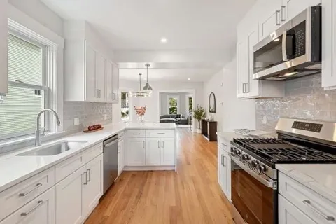 a kitchen with stainless steel appliances a sink dishwasher stove microwave and cabinets