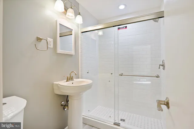 a bathroom with a sink mirror and a shower