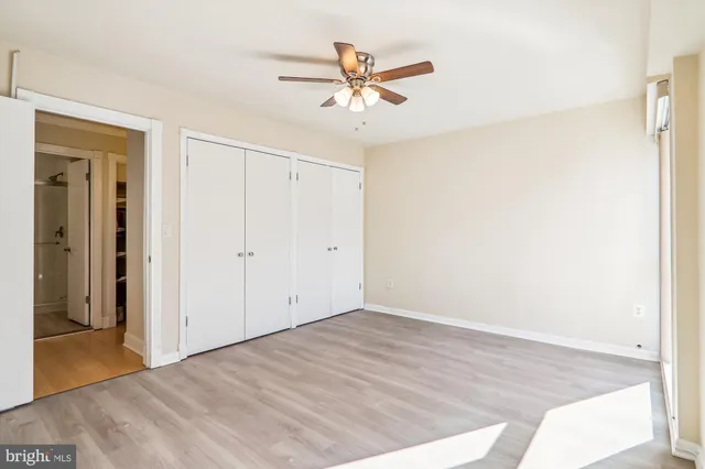 a view of a room with wooden floor and a ceiling fan