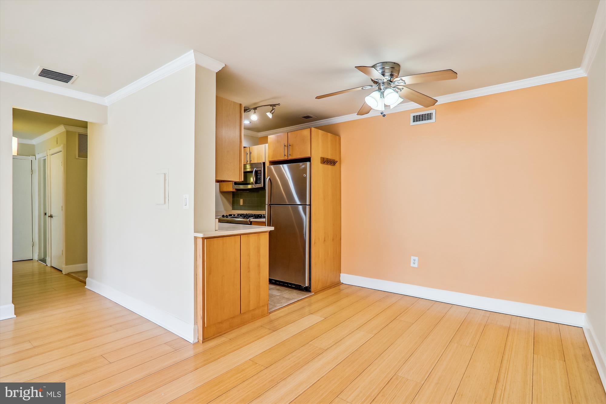 4970 Battery Lane, Unit 408 Bethesda, MD 20814 - Photo 9 of 40 a view of a kitchen with wooden floor and a ceiling fan