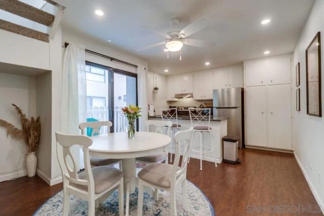 a dining room with furniture potted plants and wooden floor