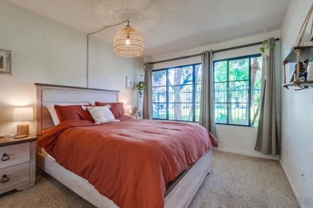 a bedroom with a bed a chandelier and a mirror