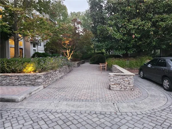 a view of a street with a bench and trees