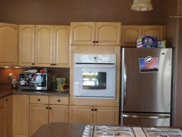 a kitchen with stainless steel appliances granite countertop a refrigerator and a stove top oven