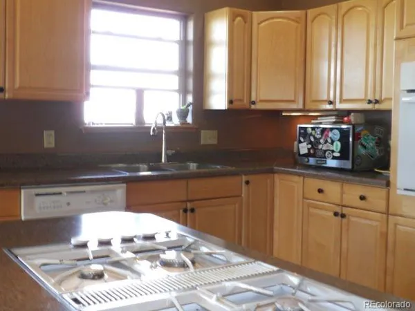 a kitchen with stainless steel appliances granite countertop a sink window and cabinets