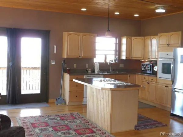 a kitchen with kitchen island granite countertop appliances cabinets and a sink