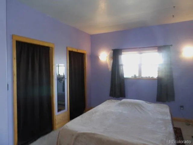 a bedroom with a bed and a mirror