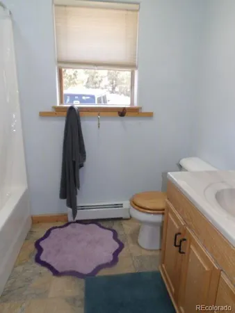 a bathroom with a toilet sink and window