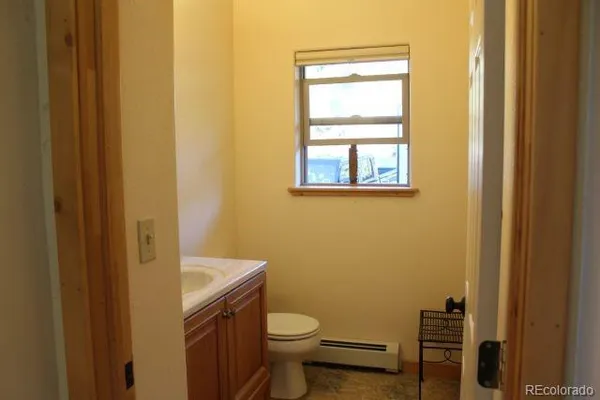a bathroom with a granite countertop toilet and a sink