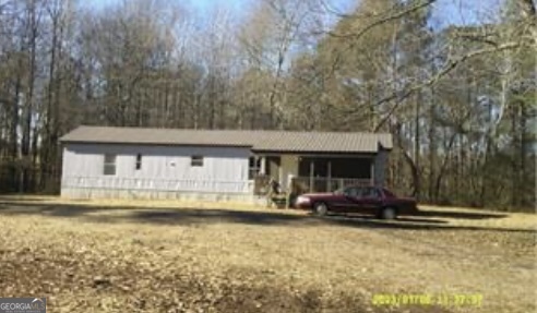 a front view of house with yard and trees in the background
