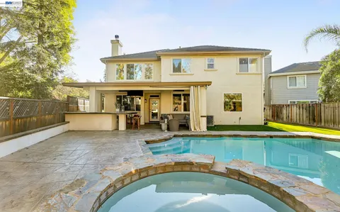 a view of a house with swimming pool and sitting area