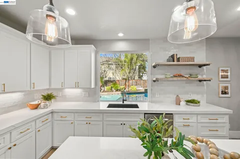 a kitchen with kitchen island white cabinets and wooden floor
