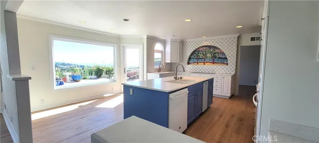 a kitchen with stainless steel appliances a sink cabinets and wooden floor