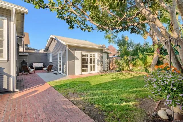 a view of a patio with a table and chairs under an umbrella with wooden fence