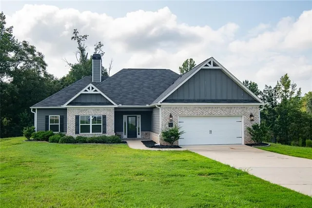 a front view of a house with a garden and yard