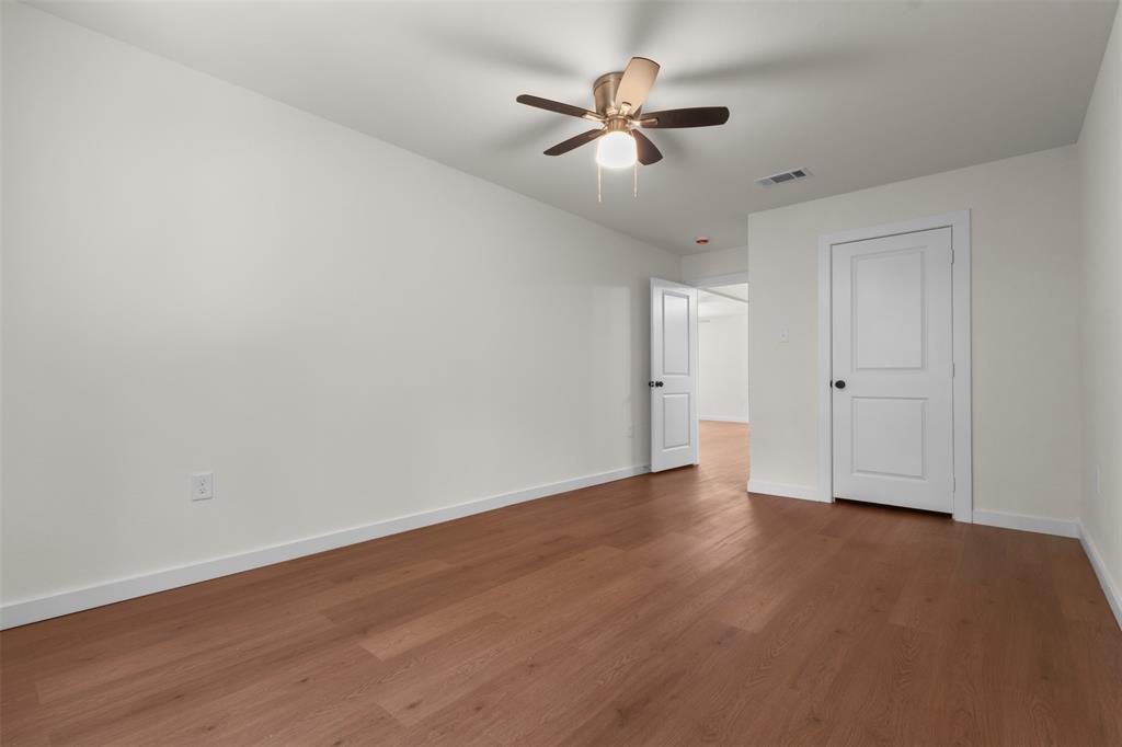 513 East Union Bower Road Irving, TX 75061 - Photo 24 of 34 Wood-finish flooring, white walls, white paneled doors, and ceiling fan with integrated lighting
