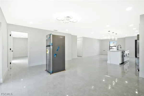 a view of kitchen with kitchen island white cabinets and refrigerator