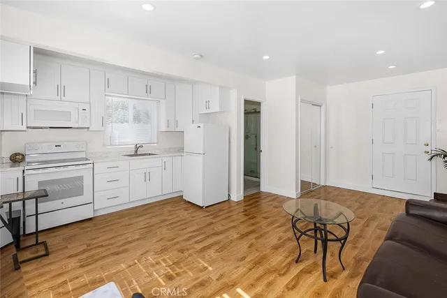 a kitchen with white cabinets and white appliances