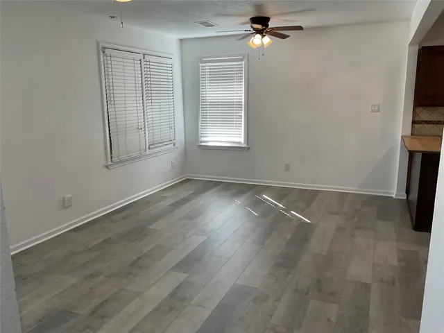 an empty room with wooden floor and cabinet
