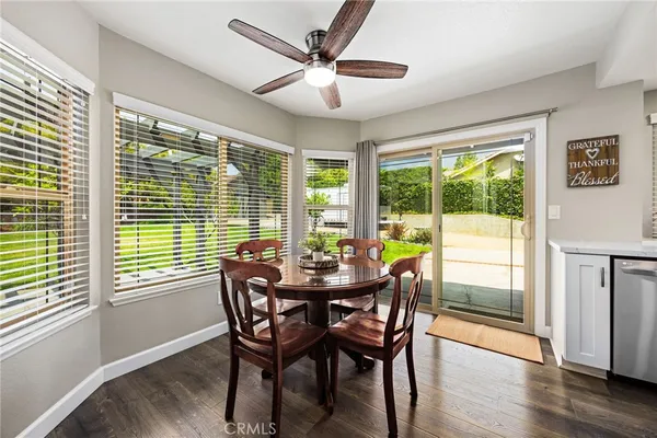 a view of a dining room with furniture a rug and wooden floor