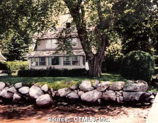 a front view of a house with a yard and fountain
