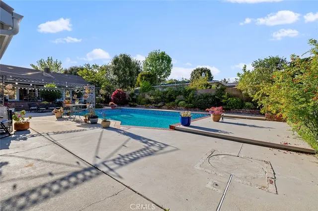 a living room with furniture flowers and wooden floor