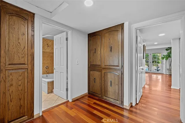 a view of a hallway with wooden floor and furniture
