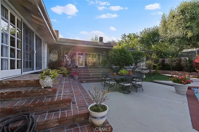 a view of a patio with chairs and potted plants