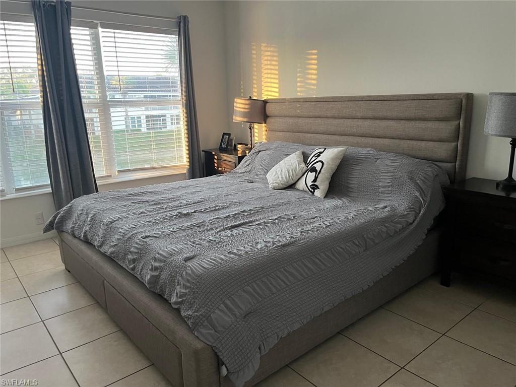 972 Hampton Circle, Unit 77 Naples, FL 34105 - Photo 14 of 24 a bed sitting in a bedroom next to a window