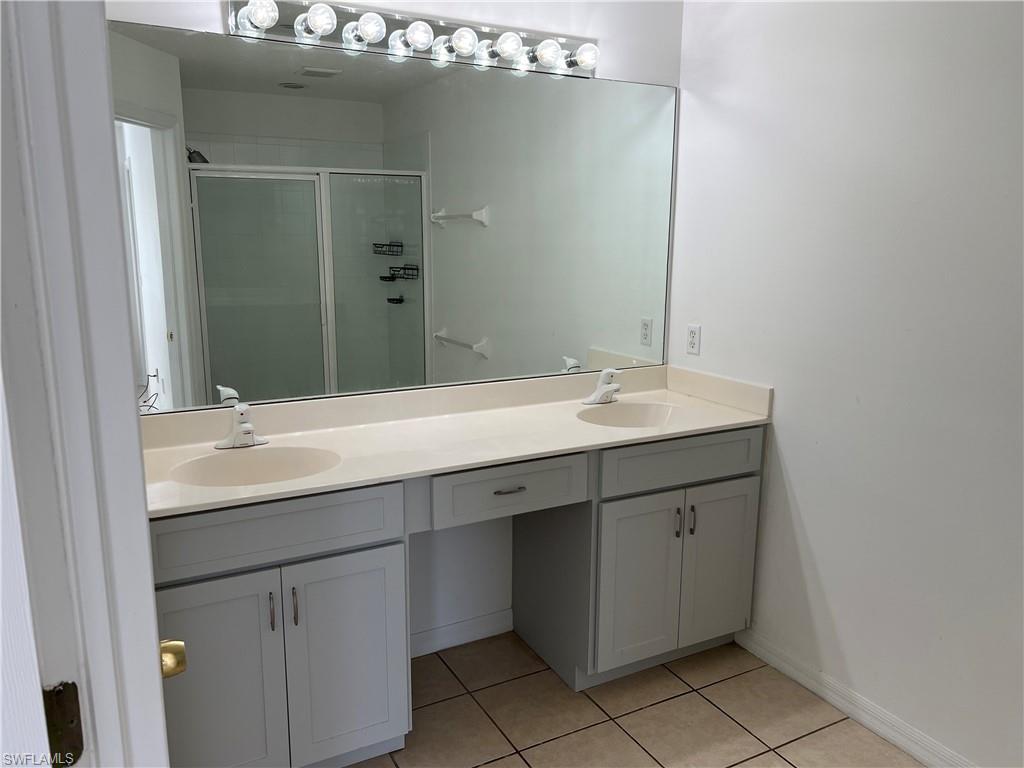 972 Hampton Circle, Unit 77 Naples, FL 34105 - Photo 15 of 24 a bathroom with a double vanity sink and mirror