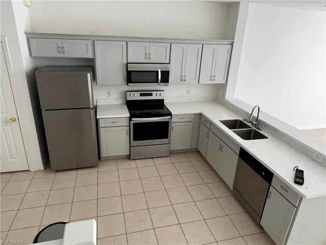 a kitchen with a sink a refrigerator and cabinets