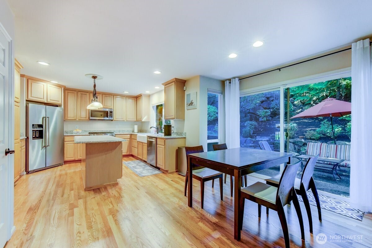 20019 27th Drive Southeast Bothell, WA 98012 - Photo 12 of 36 a kitchen with stainless steel appliances kitchen island granite countertop a dining table chairs and granite counter tops