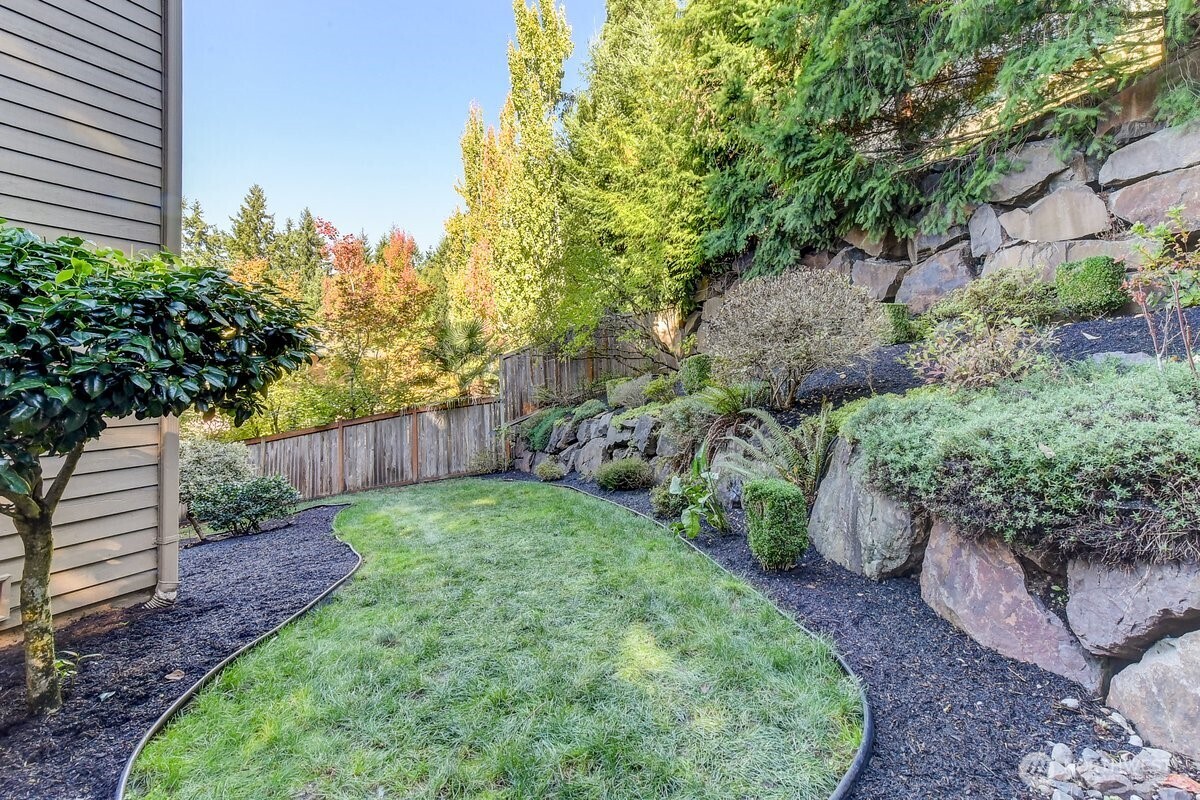 20019 27th Drive Southeast Bothell, WA 98012 - Photo 35 of 36 a view of a backyard with plants and large trees with wooden fence