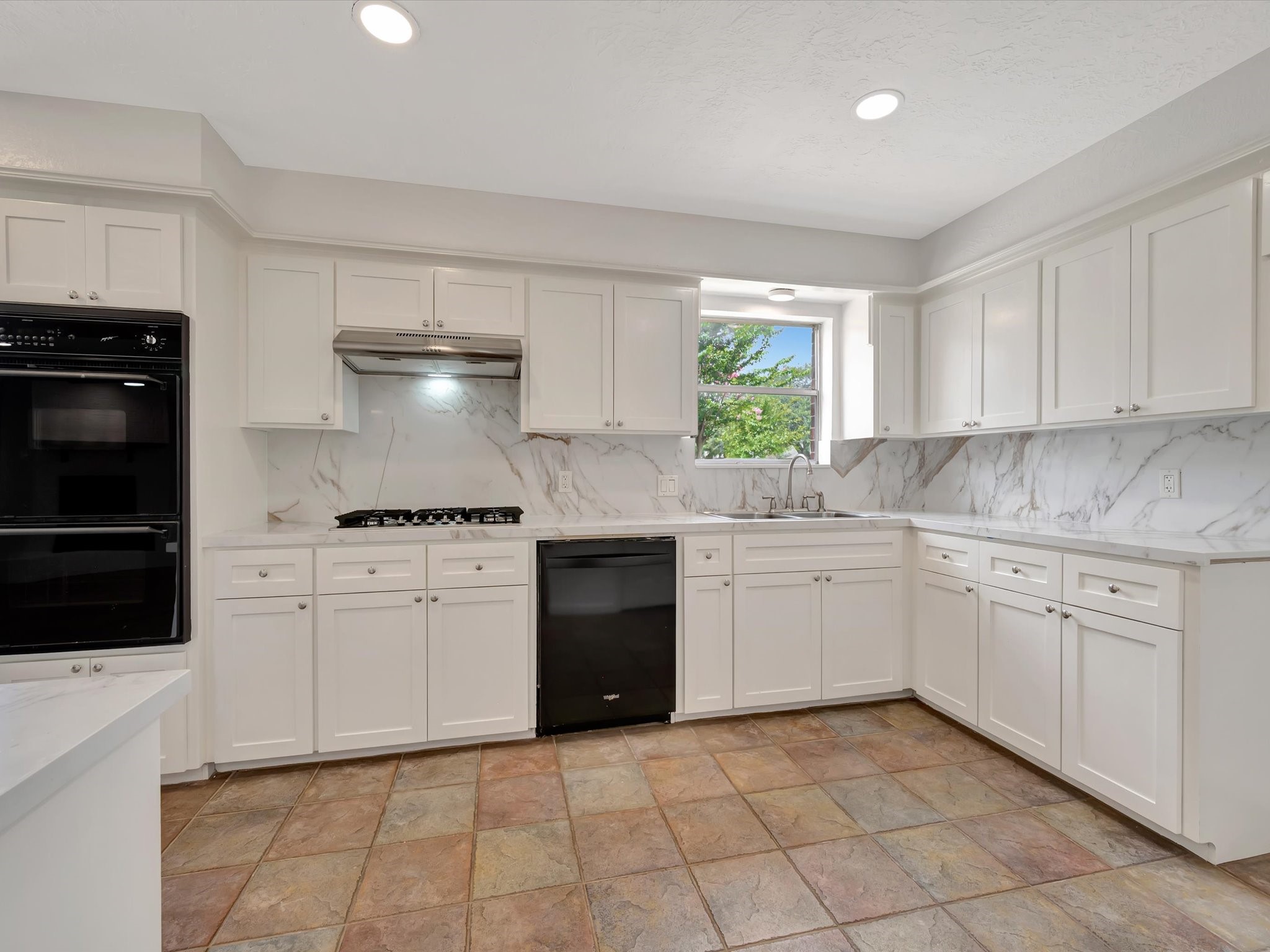 10340 Rocky Hollow Road La Porte, TX 77571 - Photo 6 of 38 Chef’s kitchen featuring custom solid wood cabinetry with soft-close doors and drawers, complemented by quartz countertops and a full quartz backsplash. Equipped with a gas cooktop, professional ventilation, and a double oven.