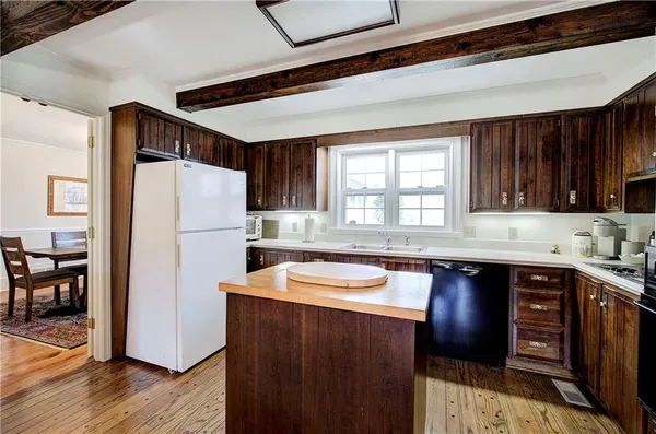 a kitchen with a sink a refrigerator and wooden cabinets