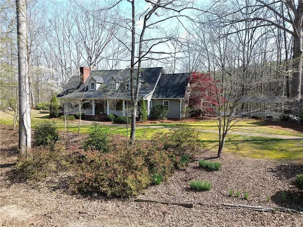 a view of a house with a yard covered with trees