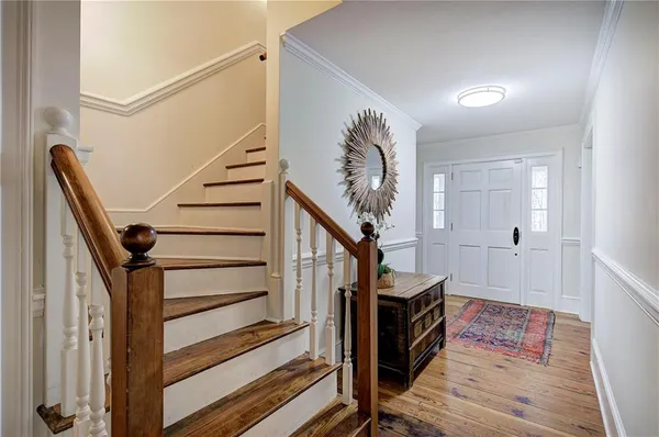a view of a hallway with wooden floor and staircase
